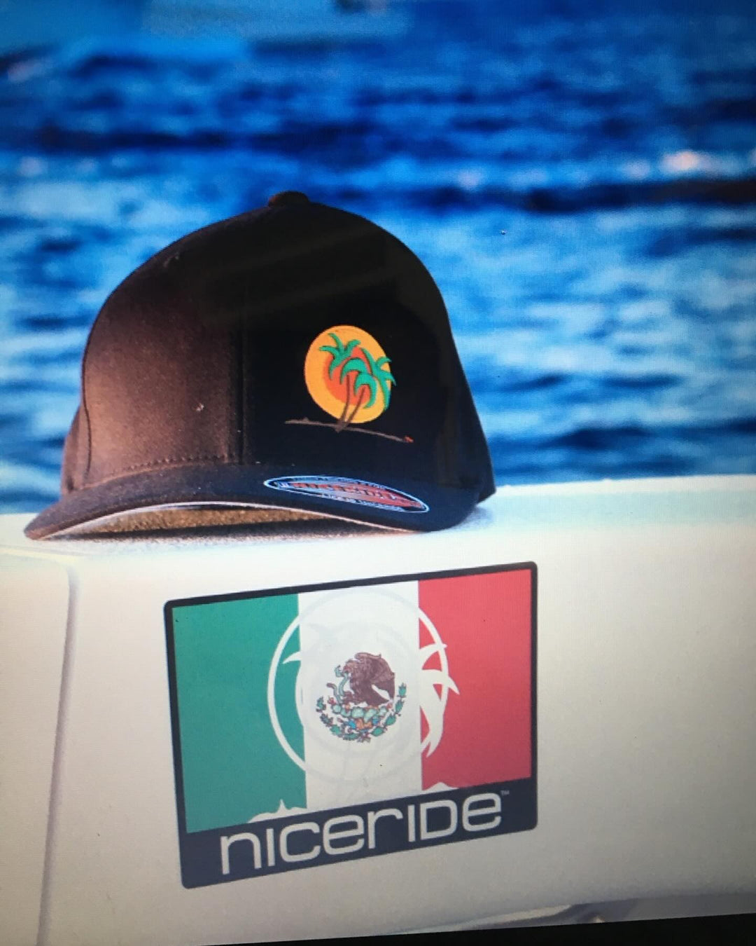 Niceride branded cap on a boat with a Mexican flag sticker in the background, symbolizing adventure at sea.