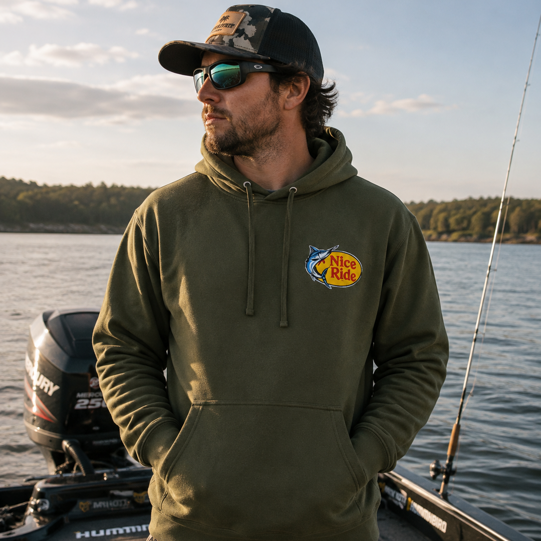Man wearing NICERIDE "Top Water" Pullover Hoodie, fishing-inspired unisex hoodie on boat.