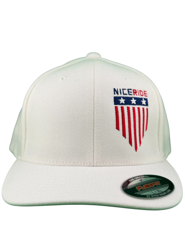 White NICERIDE baseball cap with red and blue embroidered logo and shield design on front.