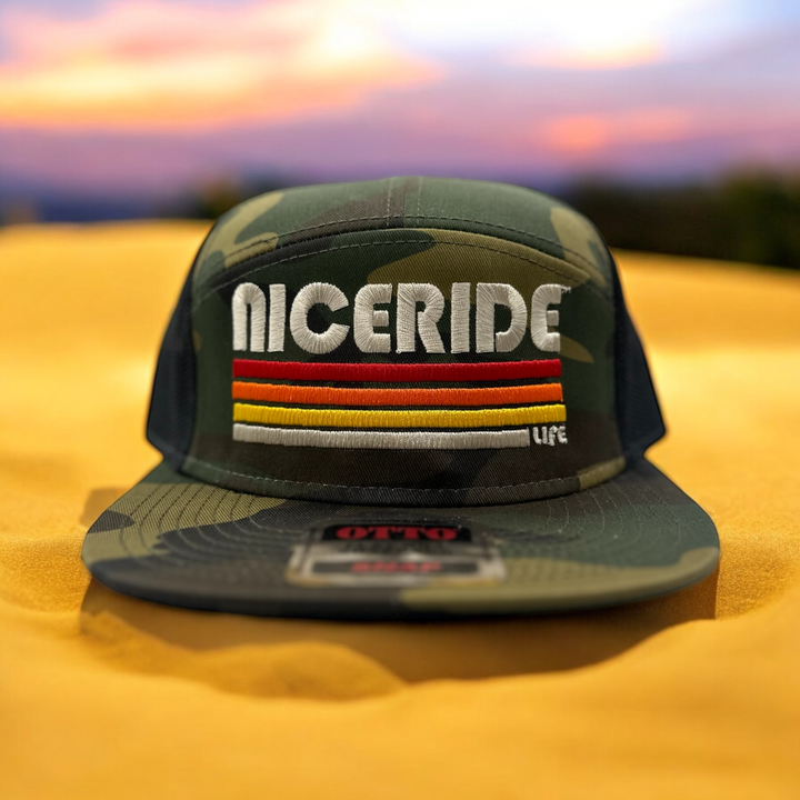 Evening Glow trucker hat by NICERIDE, featuring embroidered logo and design on a camo background.