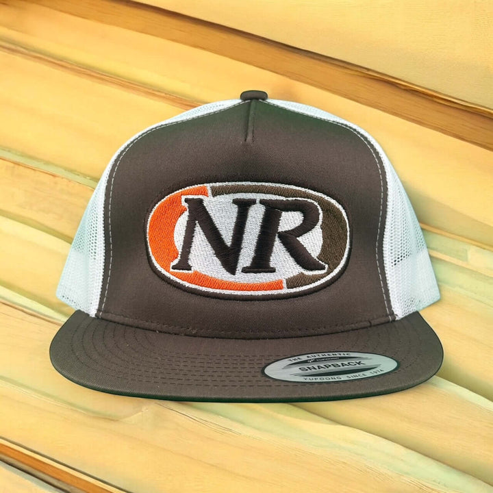 NICERIDE Float 6006 Trucker Hat with NR logo and snapback design against a rustic wooden background.