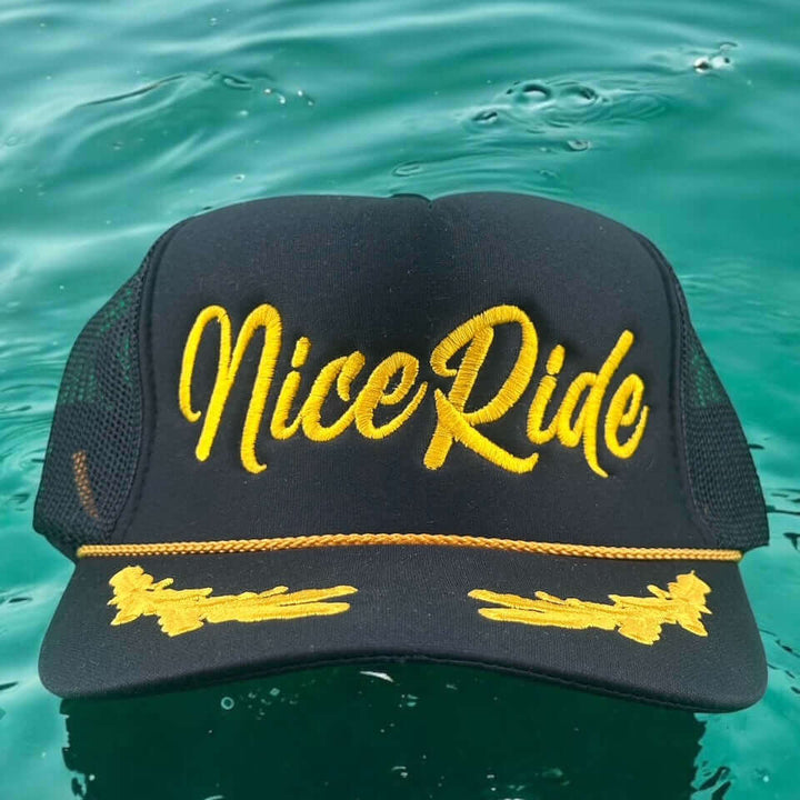Black adjustable hat with yellow Nice Ride embroidery, perfect for casual outings and outdoor activities.