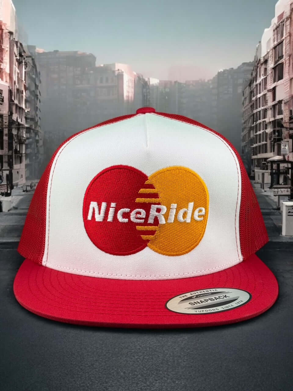 NICERIDE unisex adjustable trucker hat with red and white colors featuring embroidered logo in a cityscape background.