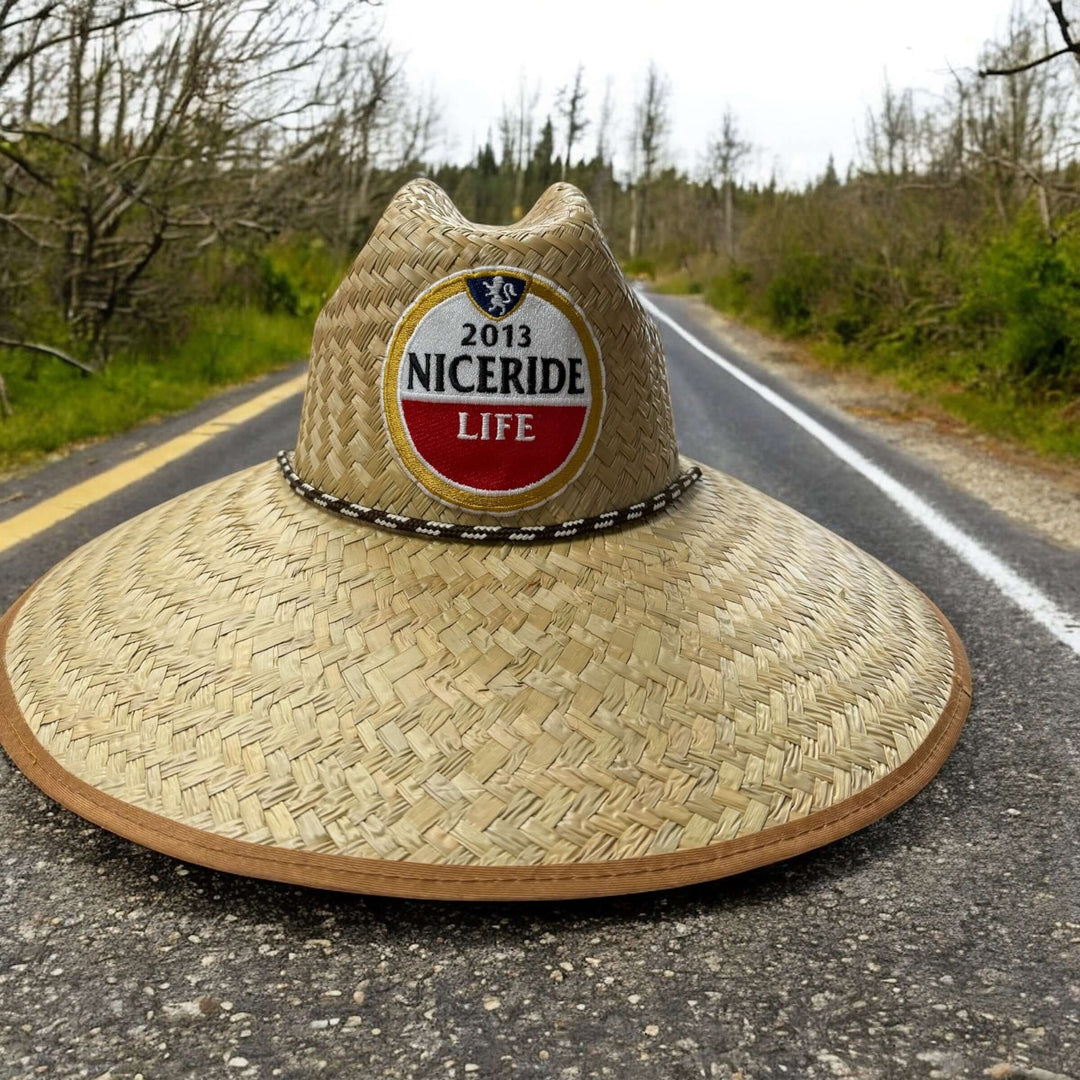 NICERIDE handwoven straw sun hat with wide brim on roadside, offering UV protection for beach and outdoor activities.
