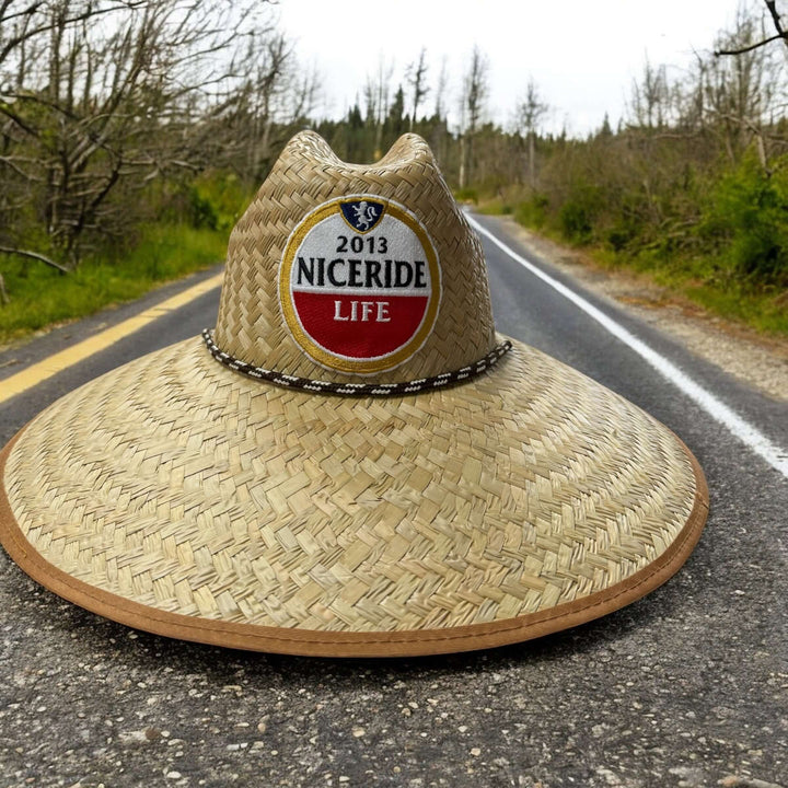 NICERIDE handwoven straw sun hat with wide brim on roadside, offering UV protection for beach and outdoor activities.