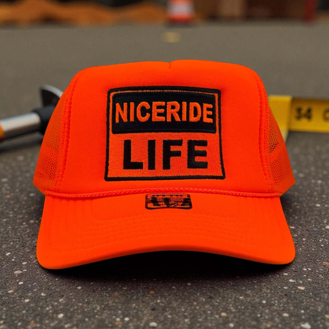 NICERIDE “Caution” Otto unisex foam trucker hat in bright orange with embroidered LIFE logo.