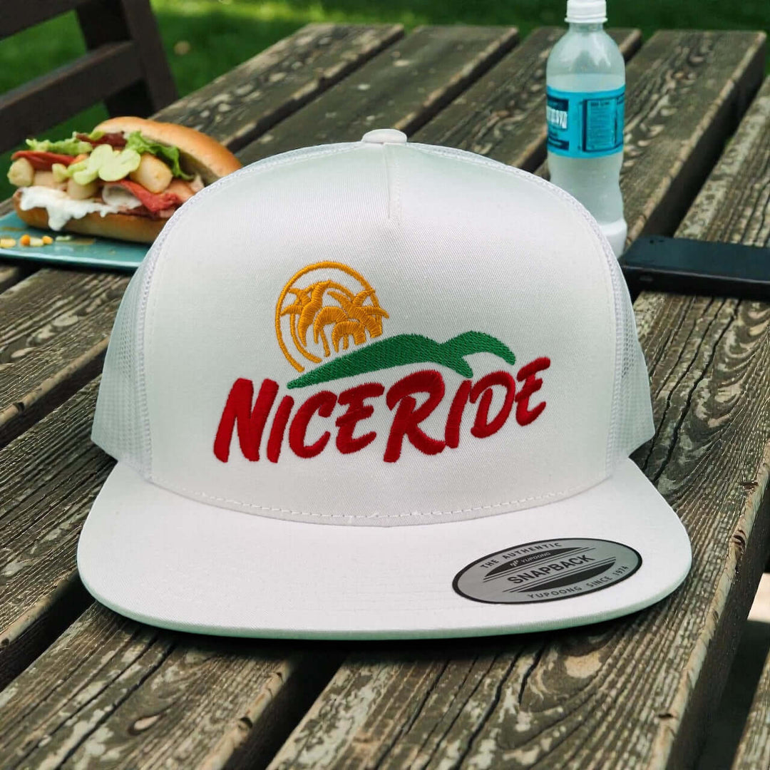 Niceride Crinkle Cut 6006 Unisex Adjustable Trucker Hat on a wooden table with food and drink in the background.