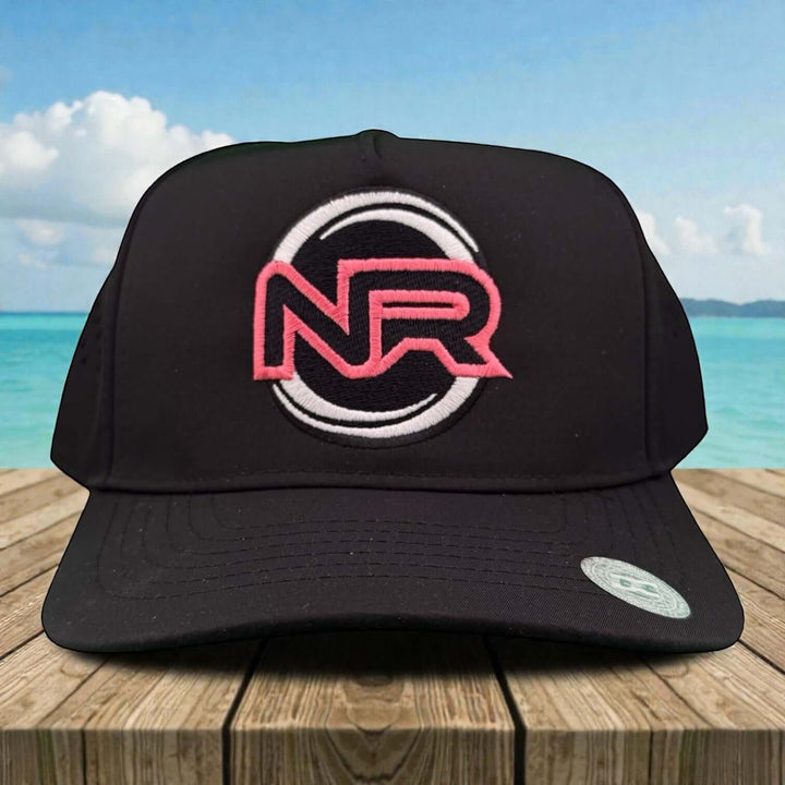 Whole Heart embroidered cap featuring NR logo in pink on a black trucker cap with a scenic background.