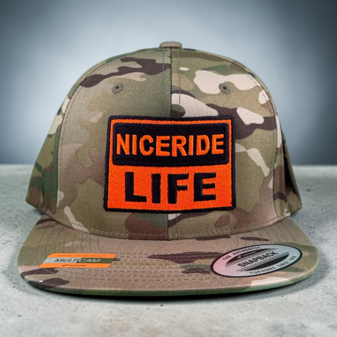 NICERIDE “CAUTION” Unisex Adjustable Multicam Trucker Hat featuring embroidered logo detail.