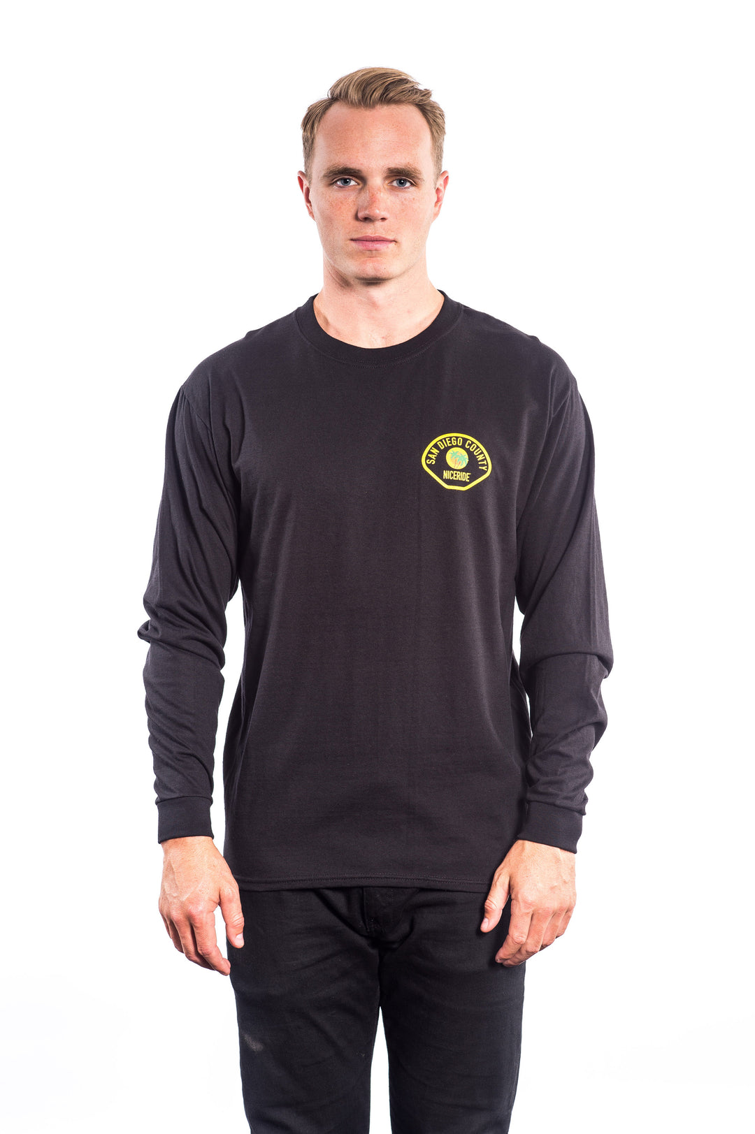 Model wearing The Badge Hanes pre-shrunk 100% cotton long sleeve shirt with logo on left chest