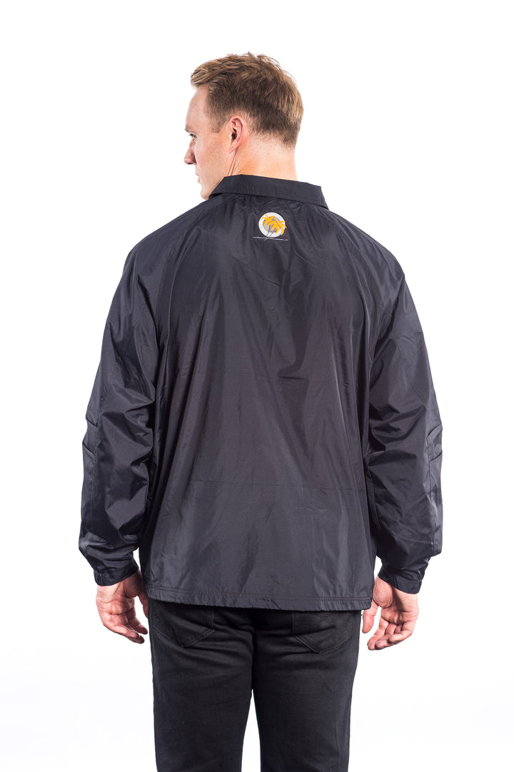 Back view of a man wearing a Coach Windbreaker Jacket with an embroidered patch.