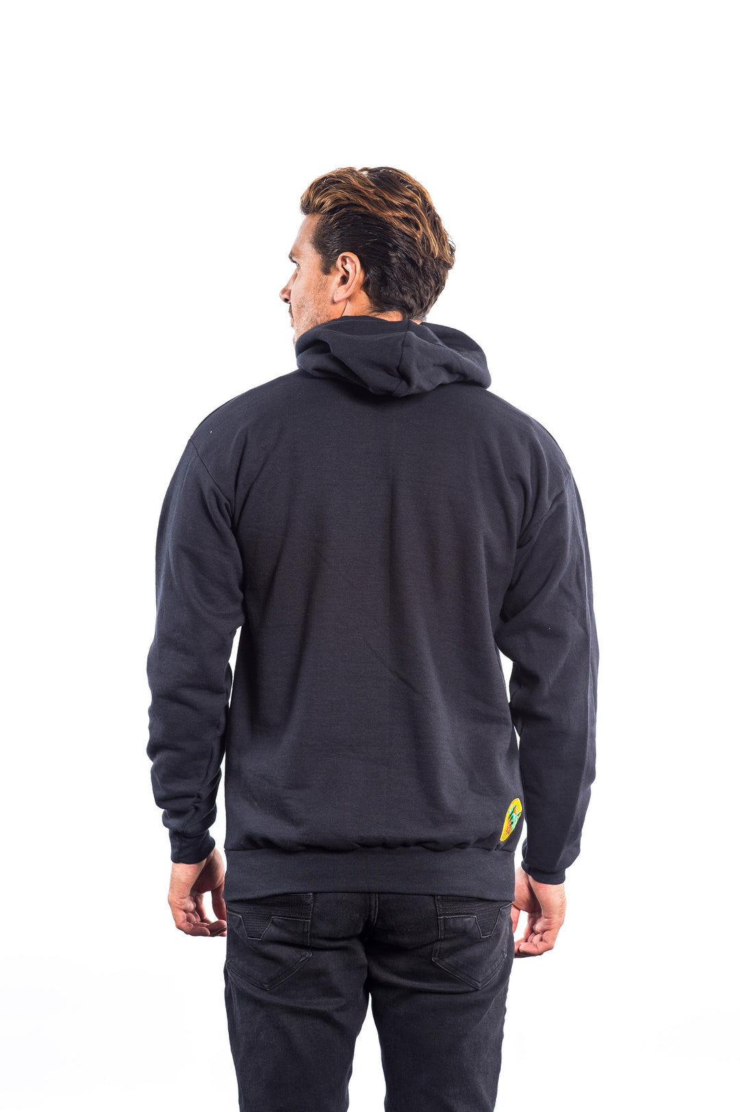 Back view of a man wearing The Badge black unisex pullover hoodie, showcasing the design and classic palm logo.