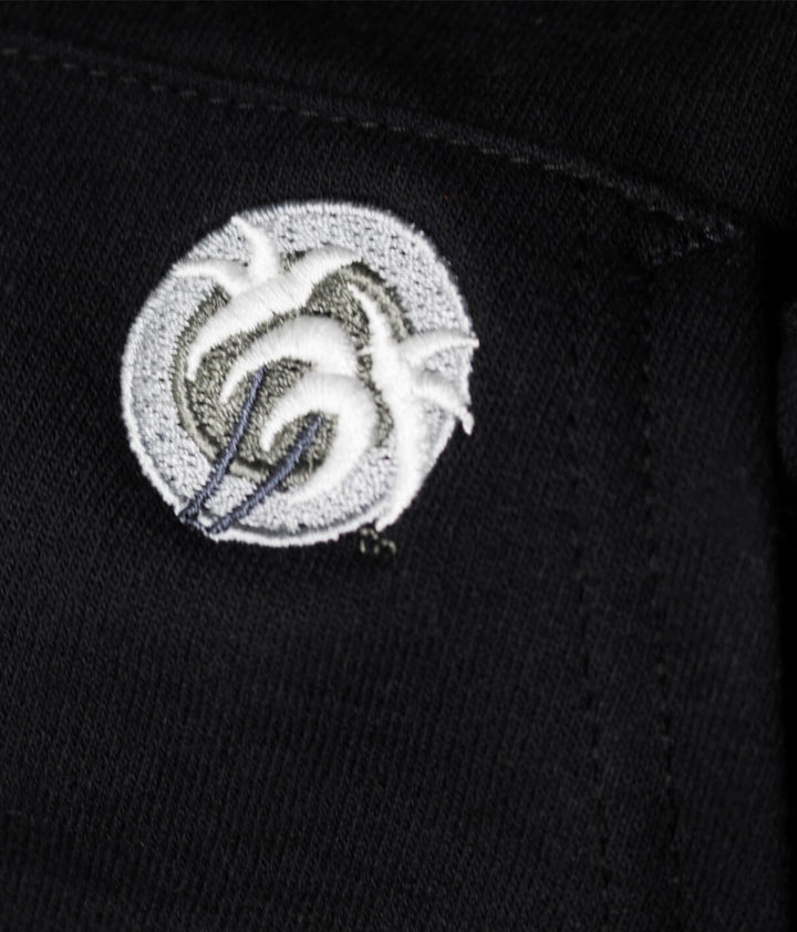 Close-up view of the NICERIDE classic palm logo embroidered on a black hoodie pocket.