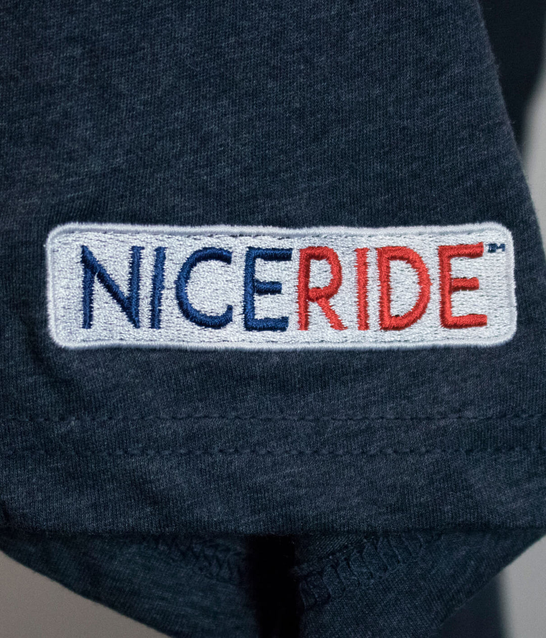 Close-up of NICERIDE logo embroidered on a short sleeve t-shirt, showcasing its quality and branding.