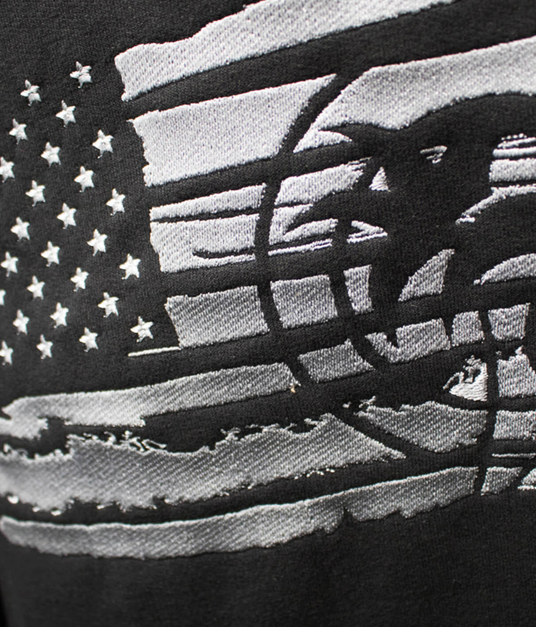 Close-up of the American flag design on the Strong Faded hoodie, featuring black and silver embroidery details.