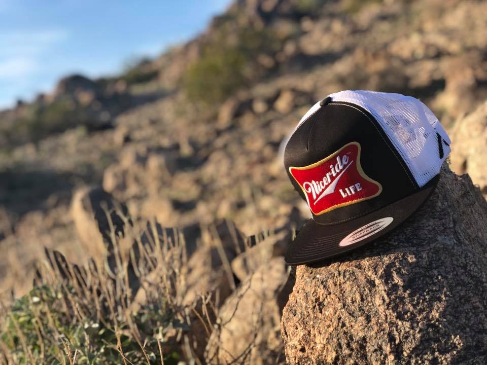 Biscuit Trucker Hat on a rock outdoors, showcasing NICERIDE&