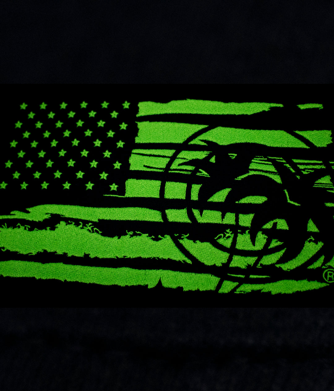 Close-up of the American flag design in green, featured on the "Strong Faded" hoodie for men and women.