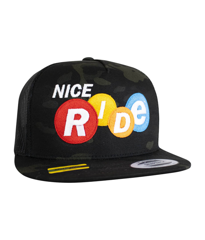 Nikki Trucker Hat featuring NICERIDE design embroidered on front in multi-color against a camo background.