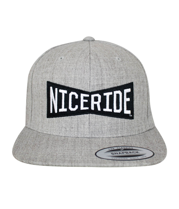 Bow Tie Snapback hat featuring NICERIDE logo embroidered on the front and side. Stylish and classic hat option.