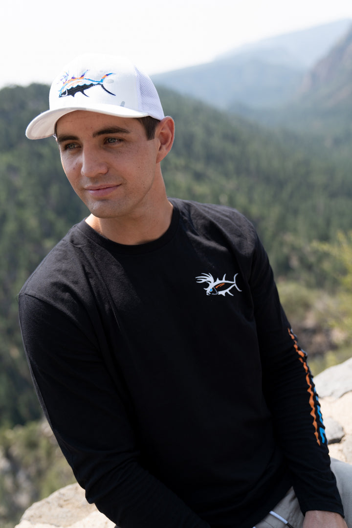 Unisex wearing a Buck-Eye Explorer meshback baseball cap while outdoors, perfect for fishing and activities.