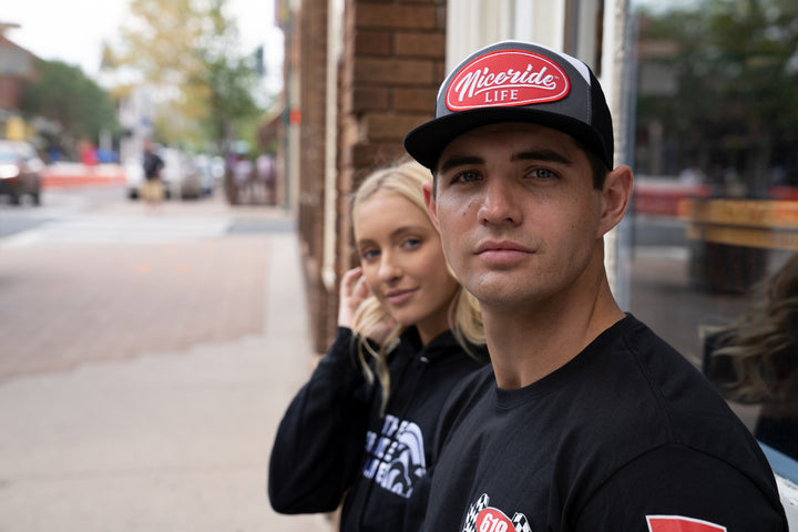 HorserPower Patch 7 Panel Trucker Snapback Hat For Men And Women worn by a young man in a street setting.