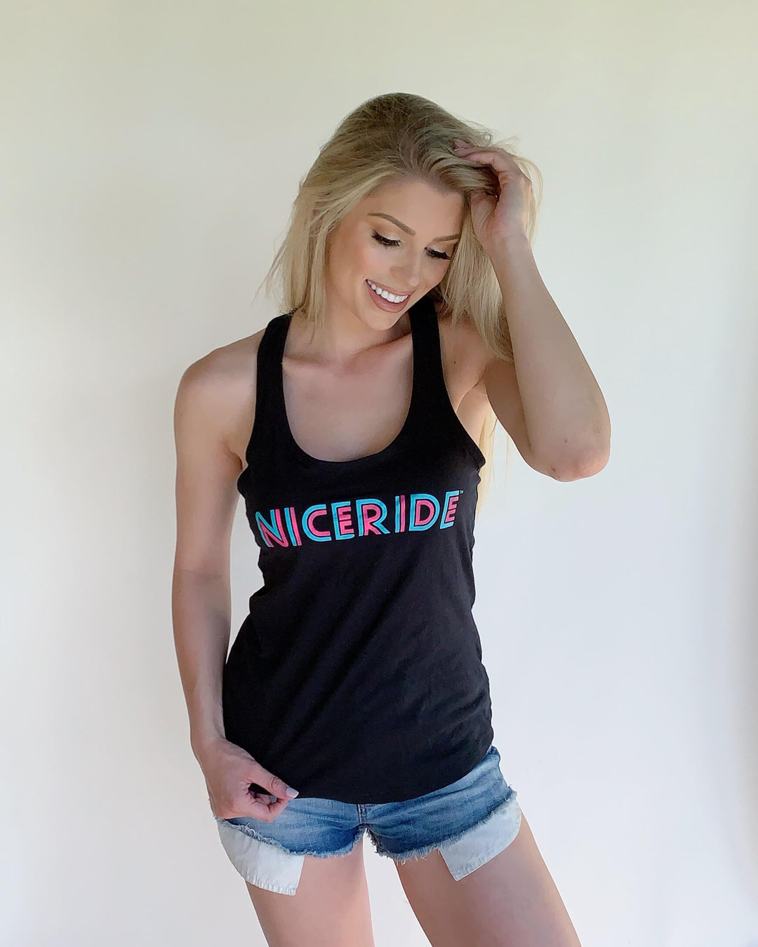 Woman wearing NICERIDE black tank top, showcasing the bold design, perfect for casual outfits.