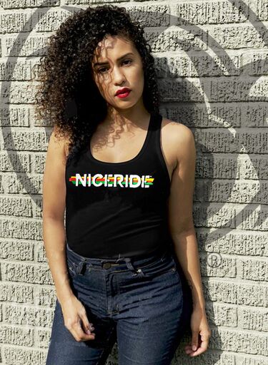 Woman wearing a black tank top featuring NICERIDE design, standing against a textured wall.